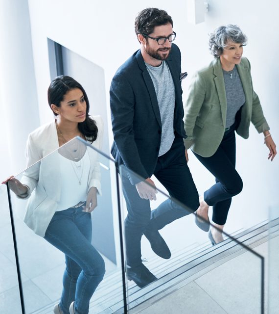 Drei Personen gehen eine Treppe hinauf